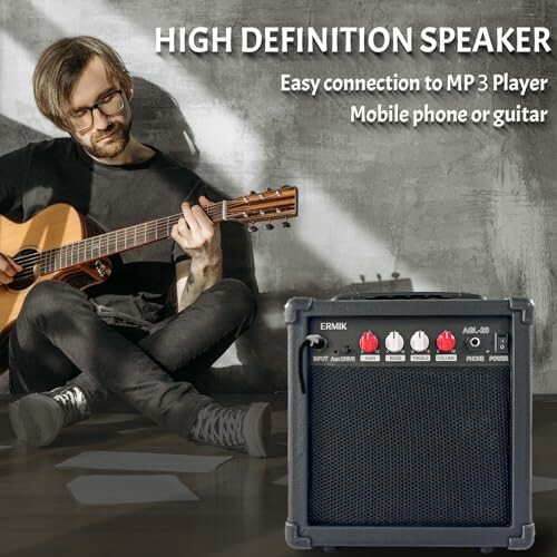 Musician with guitar next to a high definition speaker.